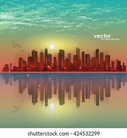 Modern night cityscape in moonlight or sunset, with reflection in water and cloudy sky