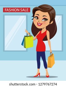 A modern woman has just finished shopping at a fashion sale. She is happily holding shopping bags in her hand.