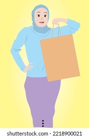 modern woman in hijab carrying paper shopping bag. woman who likes shopping