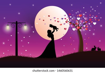 Mom holding her son on night moon and tree background with  floating little heart