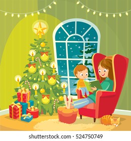 Mom mother reads christmas tales for little son seating in armchair by near the christmas tree on christmas eve.