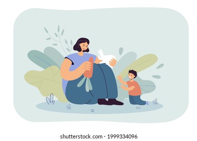 Mom and son feeding carrot to rabbit together. Flat vector illustration. Happy woman and little child sitting with white bunny. Family, parenting, animal, pet, wildlife concept for banner design