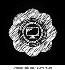 monitor icon inside chalkboard emblem on black board