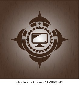 monitor icon inside wooden emblem