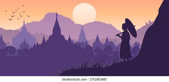 monk hold umbrella on cliff and looks for pagoda sea in Bagan,Myanmar