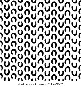 Monochromatic hand illustrated seamless vector horseshoe pattern.  Textured hand drawn U-shaped brushstroke design on a white background.