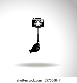 Monopod camera with hand vector icon.