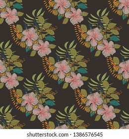 Moody floral tropical pattern design with hibiscus flowers and leaves on dark background. Exotic seamless pattern with tropical leaves. Ethnic Background with Hawaiian flowers and plants.