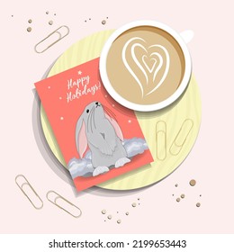 Morning post. A cup of coffee and a card with the symbol of 2023. Congratulatory Christmas card with a rabbit. View TOP. RABBIT.