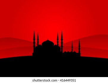 A mosque silhouette against the red sky and mountains