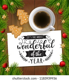 It's the most wonderful time of the year. Vector wood background with christmas tree branches, red balls,  cup of coffee, gingerbread and paper with lettering. Christmas greeting illustration