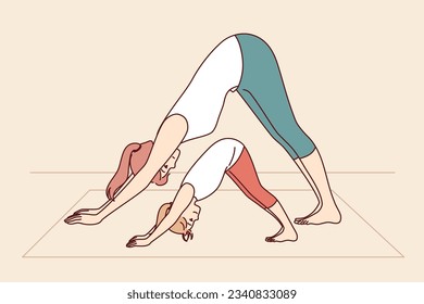 Mother and daughter are engaged in yoga and exercises, leading healthy lifestyle and learning good habits that improve well-being. Woman with little girl doing yoga pose adho mukha svanasana together