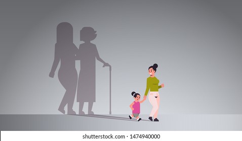 mother with daughter holding hands shadow of young and mature woman standing together imagination aspiration concept full length flat horizontal