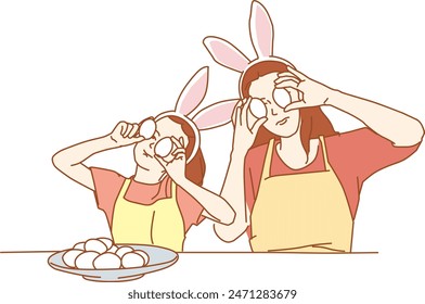 mother and daughter holding painted colorful eggs while decorating them - easte