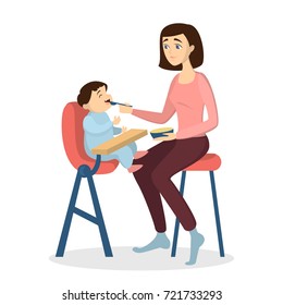 Mother feeding baby with spoon in baby chair on white background.