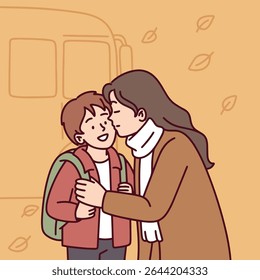 Mother gently adjusts scarf of child while saying goodbye before school bus ride on a chilly autumn morning