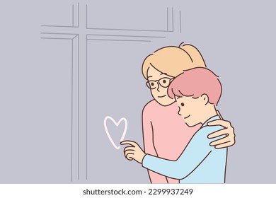 Mother hugs son draws heart window sweaty in cold winter weather  Nanny hugs little boy and inherent heart  remembering parents   missing mom   dad who went business trip