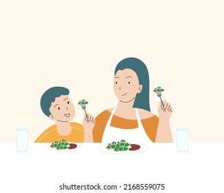 Mother and son enjoy eating with vegetables. Healthy eating concept.