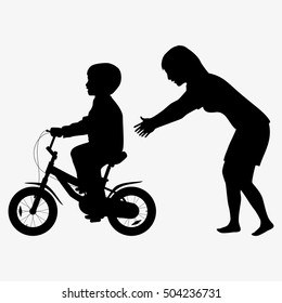 Mother teaches a child to ride a bike silhouette