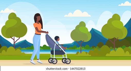 mother with toddler son in stroller walking outdoor african american woman pushing pram with child happy family motherhood concept urban city park landscape background full length horizontal