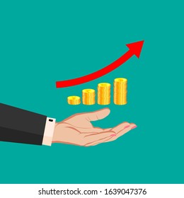 Motivating illustration for a business company, office, corporation - The hand of a business woman in a suit holds stacks of coins in the form of a growing graph of profits, sales and a red arrow