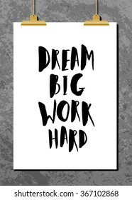 Motivational quote poster with golden clips against an old concrete wall. "Dream Big Work Hard" brush lettered quote. Modern and stylish design, A4 size, scalable to any dimension.