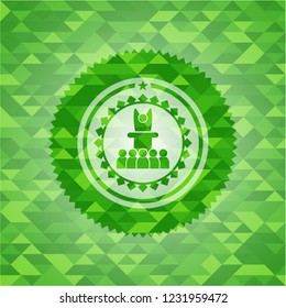 motivational speech icon inside green emblem with triangle mosaic background
