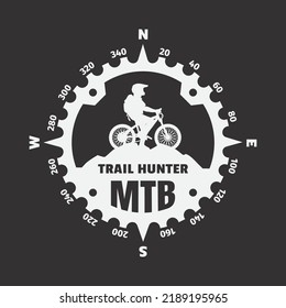 Mountain biker, logo in the form of a compass on a dark background.