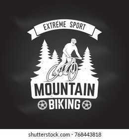 Mountain biking. Vector illustration on the chalkboard. Concept for shirt or logo, print, stamp or tee. Vintage typography design with man riding bike and forest silhouette.