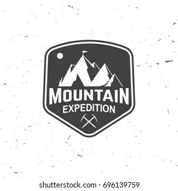 Mountain expedition badge. Vector illustration. Concept for shirt or logo, print, stamp or tee. Vintage typography design with ice axe and mountain silhouette.
