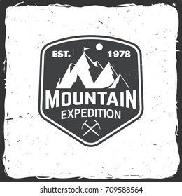 Mountain expedition badge. Vector illustration. Concept for shirt or logo, print, stamp or tee. Vintage typography design with ice axe and mountain silhouette.