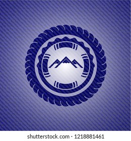 mountain icon inside badge with denim background