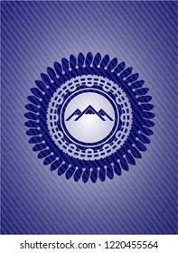 mountain icon inside badge with denim background