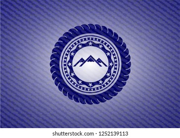 mountain icon inside badge with denim background