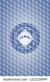 mountain icon inside blue badge with geometric pattern.