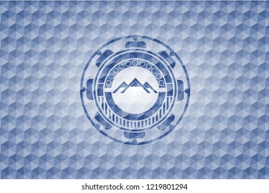 mountain icon inside blue emblem with geometric pattern background.