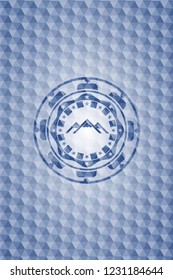 mountain icon inside blue emblem or badge with abstract geometric pattern background.