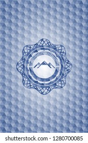 mountain icon inside blue emblem or badge with abstract geometric pattern background.