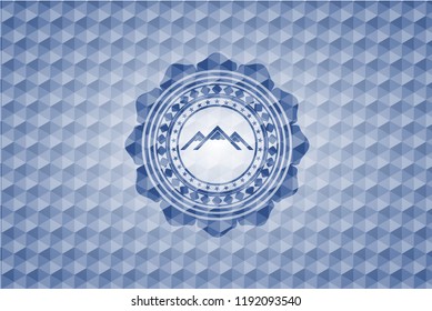 mountain icon inside blue hexagon emblem.