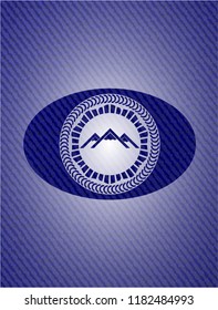 mountain icon inside emblem with denim texture