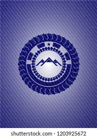 mountain icon inside emblem with denim texture