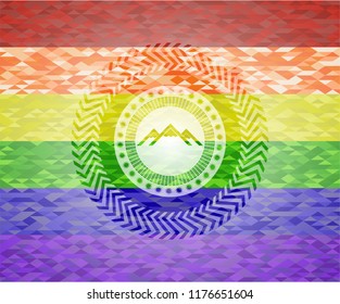 mountain icon inside emblem on mosaic background with the colors of the LGBT flag