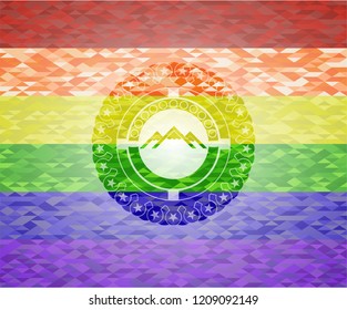 mountain icon inside emblem on mosaic background with the colors of the LGBT flag