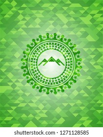 mountain icon inside green emblem with mosaic ecological style background