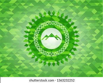 mountain icon inside green emblem with triangle mosaic background