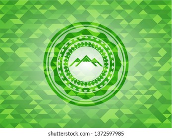 mountain icon inside green emblem with mosaic ecological style background