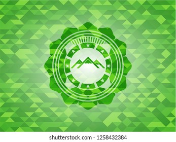 mountain icon inside green mosaic emblem