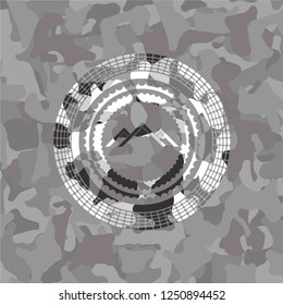 mountain icon inside grey camouflage emblem