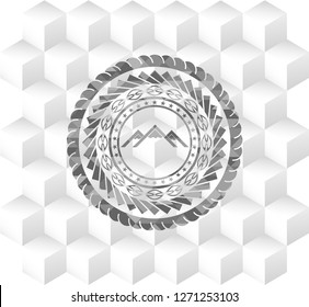 mountain icon inside grey emblem with geometric cube white background