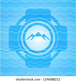 mountain icon inside light blue wave style badge.